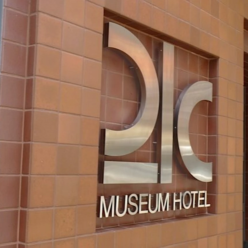 The "21C Museum Hotel" sign in metal letters on a brick wall.