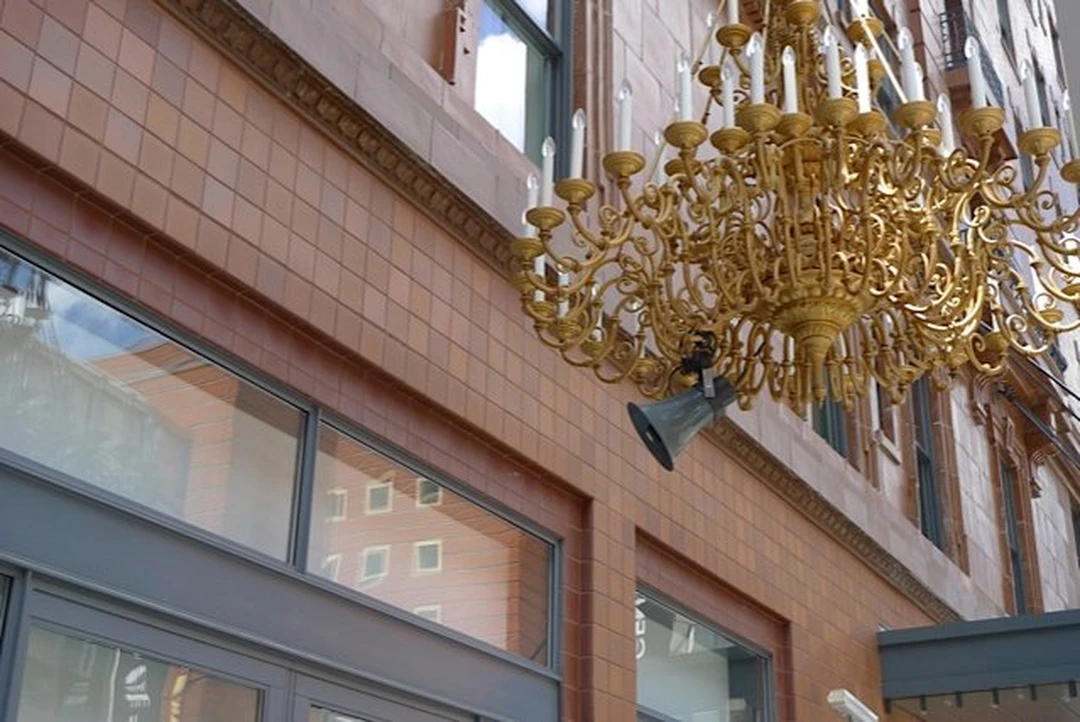 The entrance of the 21C Museum Hotel with a large golden chandelier hanging over the door.