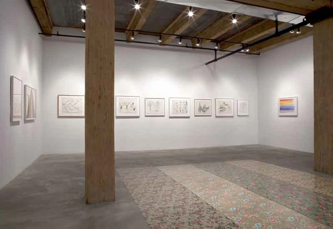 Installation view of the exhibition, a gallery room with framed drawings on the walls.