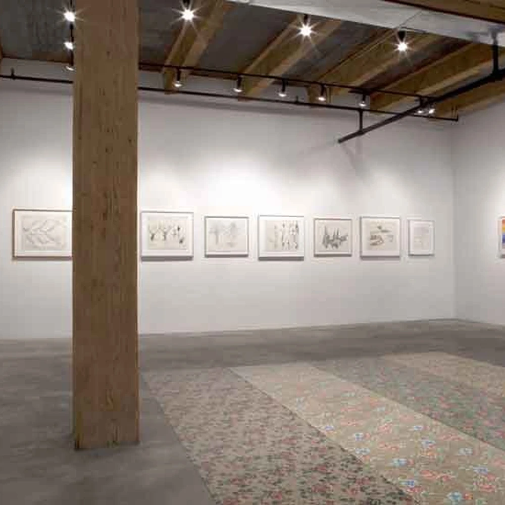 Installation view of the exhibition, a gallery room with framed drawings on the walls.