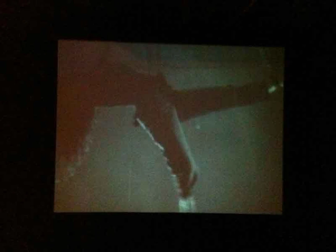 Dark projection, close-up of an outstretched leg.