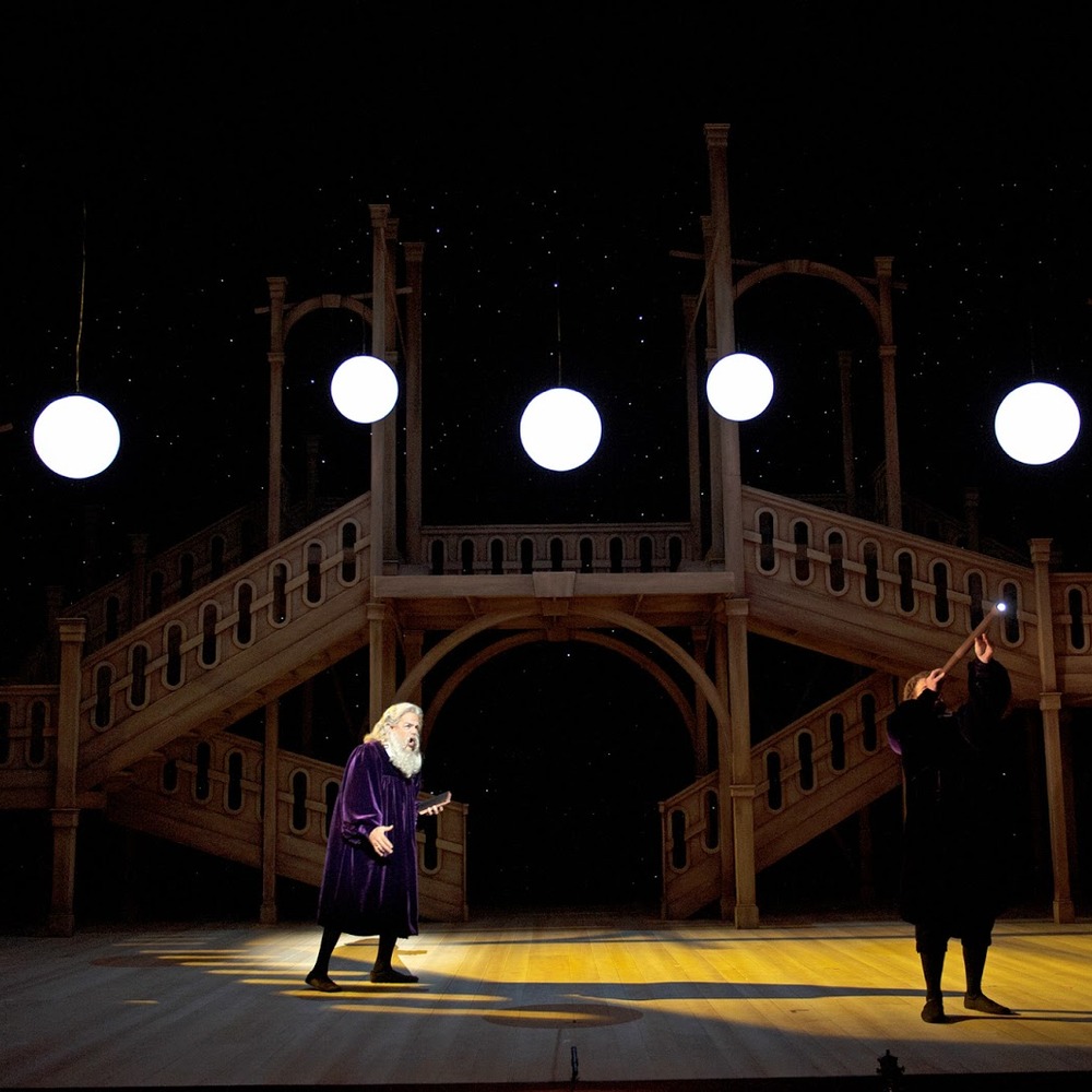 Stage of Cincinnati Opera's Galileo Galilei: wooden staircases and glowing spheres.