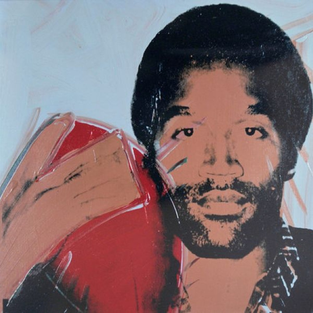 Square crop of Warhol’s silkscreen portrait of O.J. Simpson, showing his face in peach and orange tones with black hair and beard.