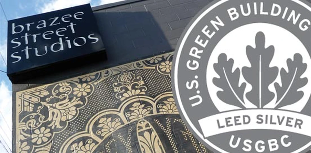 The Brazee Street Studios sign on the brick building facade in Oakley, Cincinnati, with a decorative patterned glass panel below and a LEED Silver plaque at right.