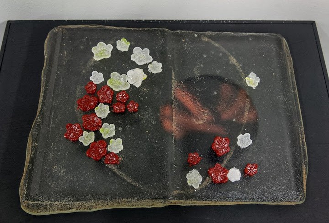 Detail of cast glass book with collar and circular video element