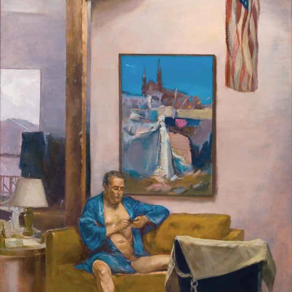 Oil painting of a sunlit studio interior under a skylight: a man in a blue robe sits on a mustard-yellow sofa beneath a framed cityscape painting, with an American flag hanging beside him.