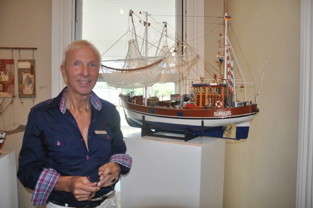 Ship modelmaker Guenther Waesch poses with his model ship Sirius at the opening of the exhibition