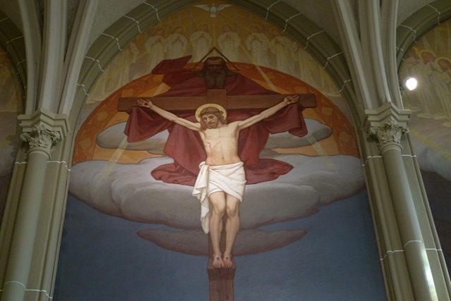 Detail of the central Crucifixion panel: Christ on the cross, with a bearded, cloaked God the Father holding the arms of the cross and the dove of the Holy Spirit above.