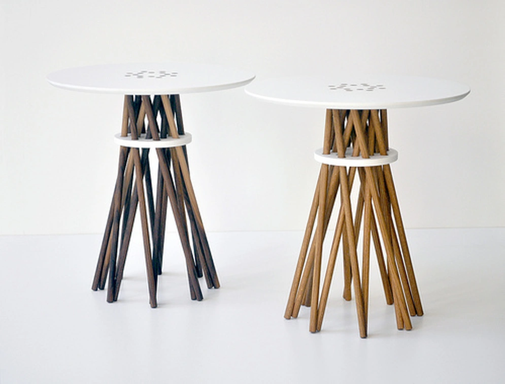 Tim Karoleff, Bundle Side Table: two round white side tables, each with a bundle of slender wooden legs gathered through a white ring, one in dark wood and one in light wood.