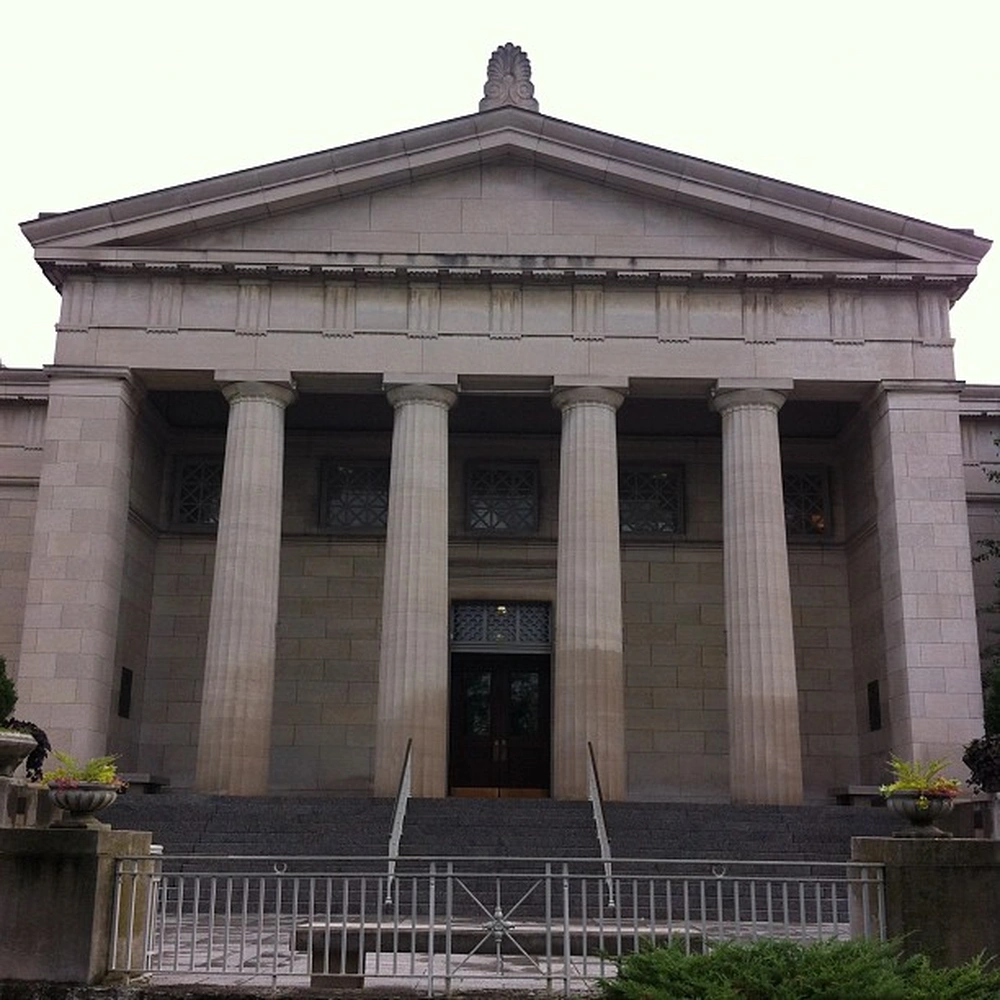 Stone portico with columns and a pediment on the Cincinnati Art Museum, with steps and a metal railing in front.