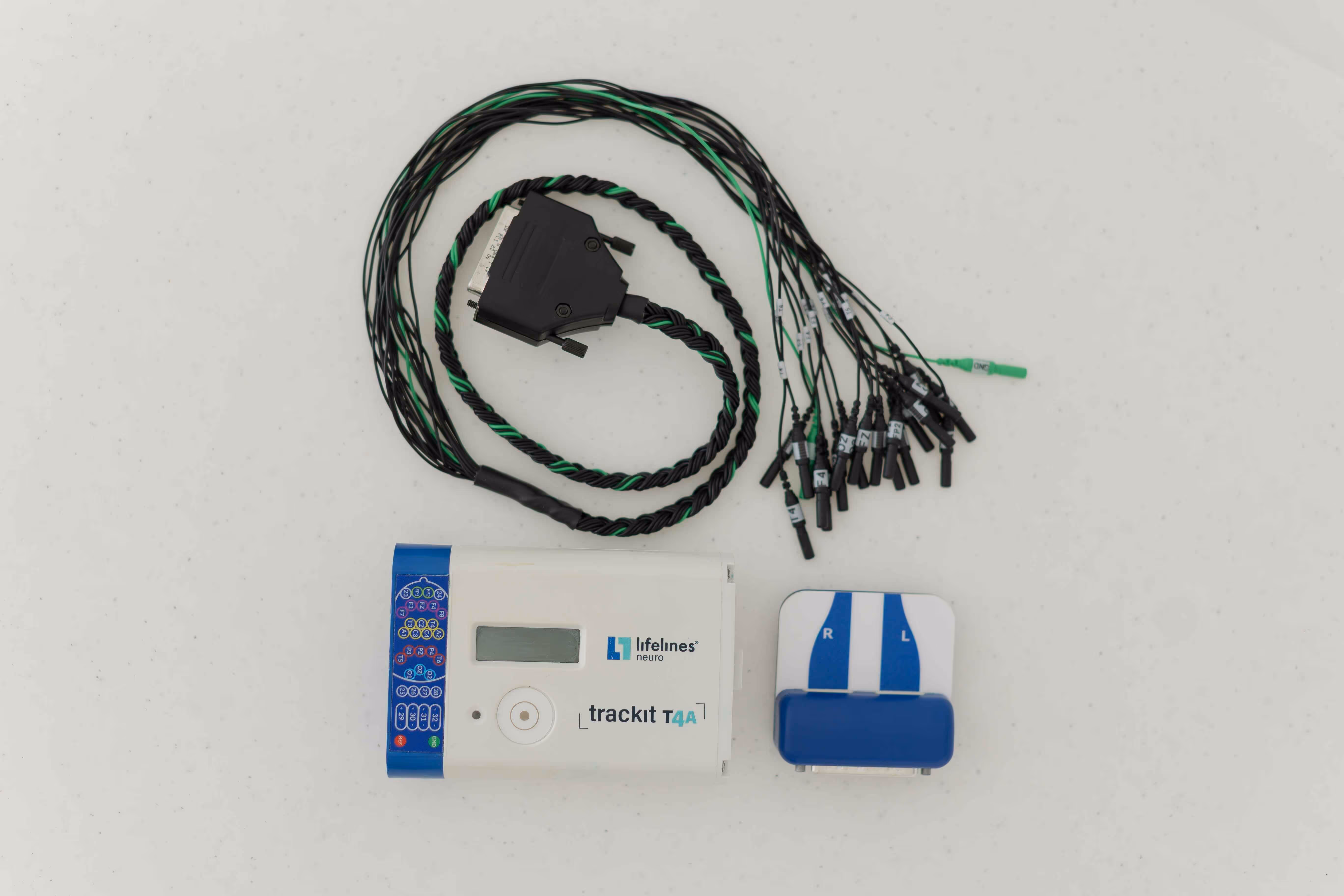EEG device kit including a Lifelines Neuro trackit T4A unit, multi-electrode cable, and a headband sensor marked with R and L.