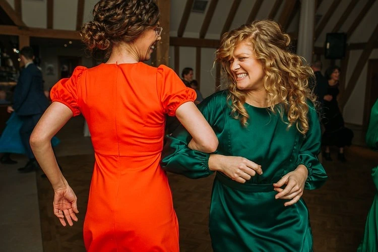 Friends linking arms during a Bristol ceilidh band performance