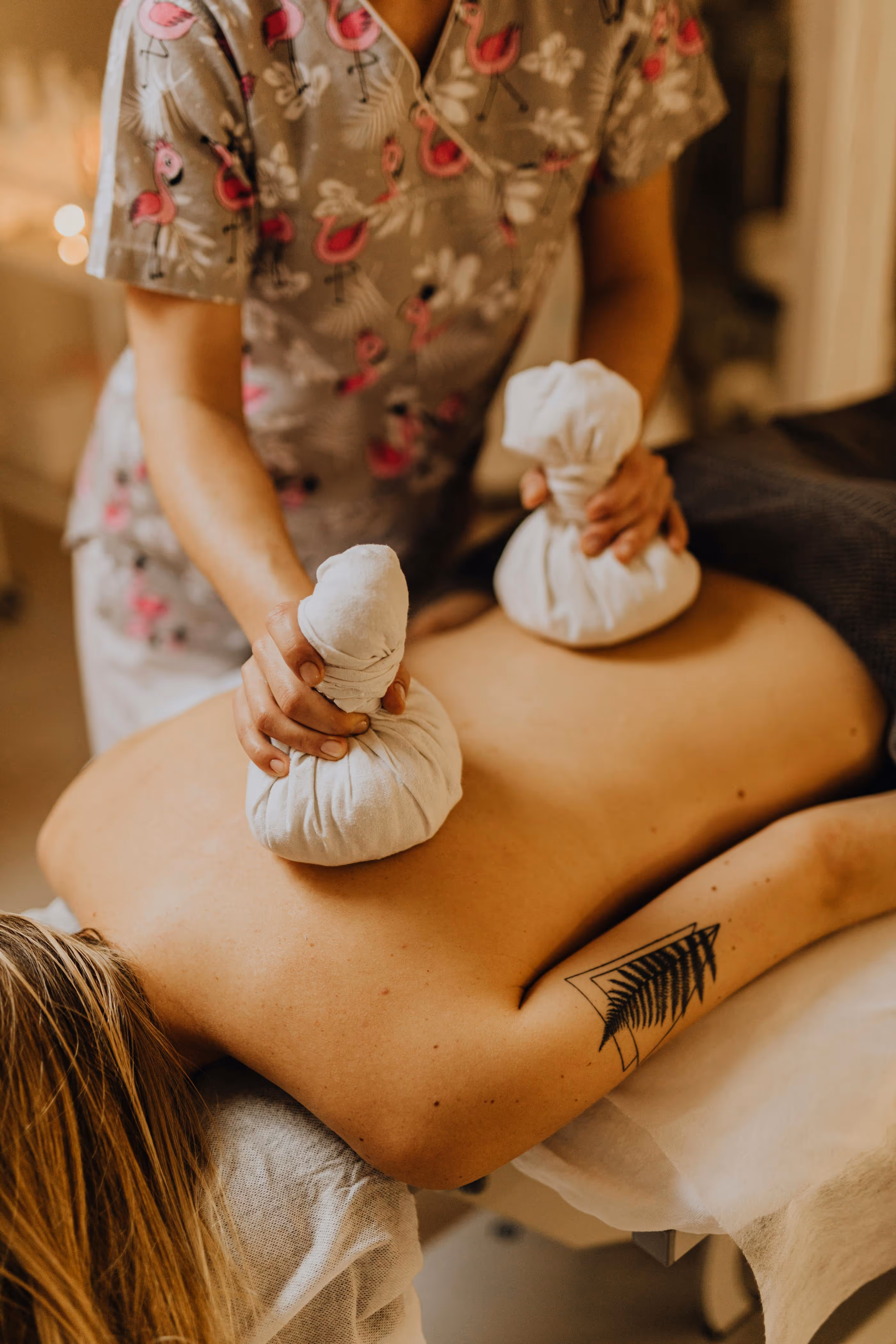 Therapist using herbal compress on back