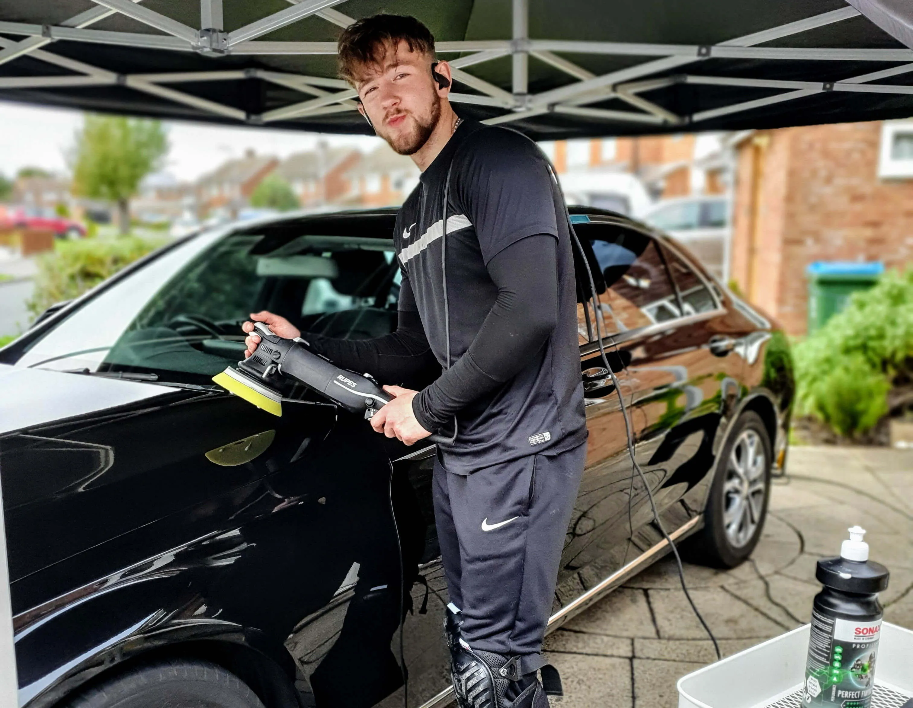 owner Emil Dygas polishing a car on his drive at home