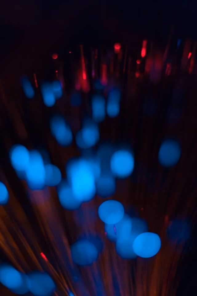 Unschärfepunkte von blauen und roten Lichtern in einem dunklen Hintergrund.