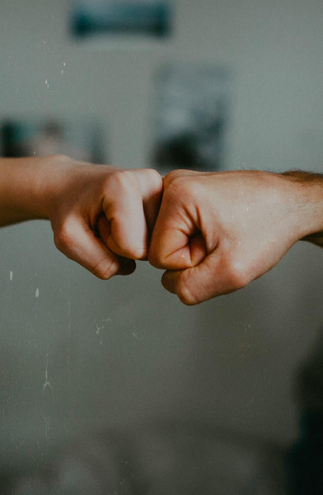 Two clenched fists bumping each other in a gesture of greeting or agreement.