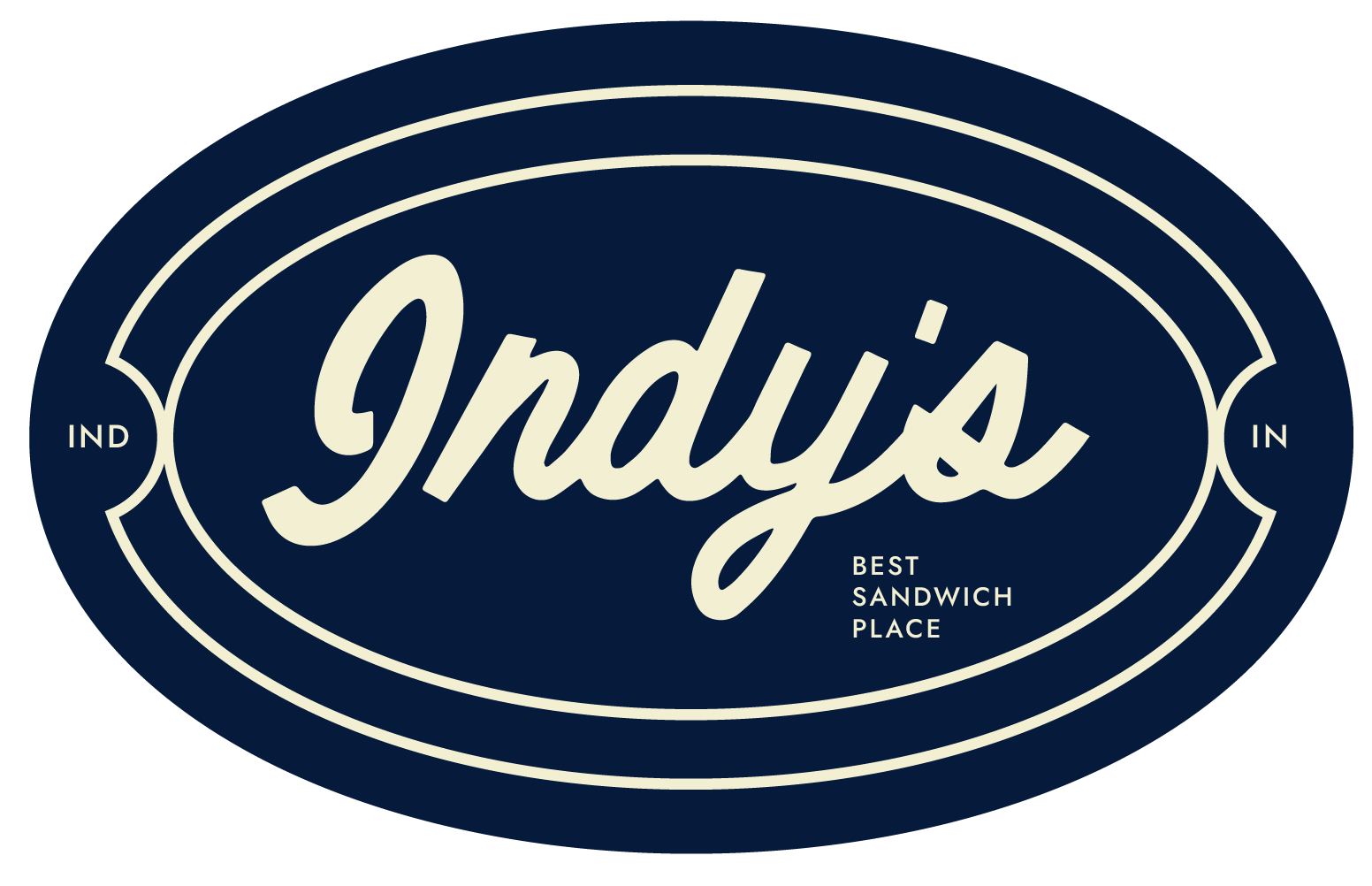 Navy blue oval logo with cream text reading 'Indy's' in script, and smaller text saying 'Best Sandwich Place' with 'IND' on left and 'IN' on right sides.