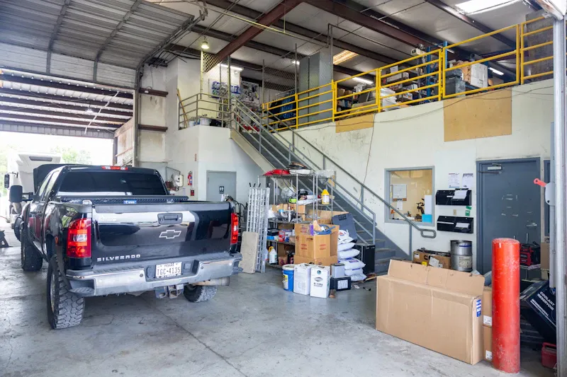 Heavy-duty repair shop interior with service office, parts storage, and a service truck parked inside the maintenance facility.