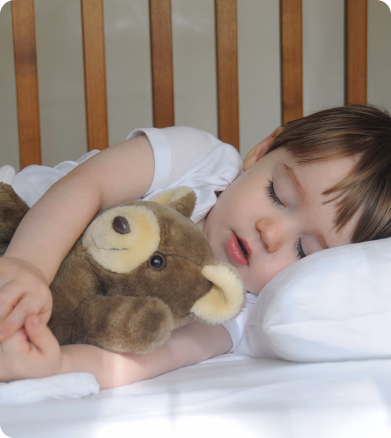 A young child asleep in their own bed