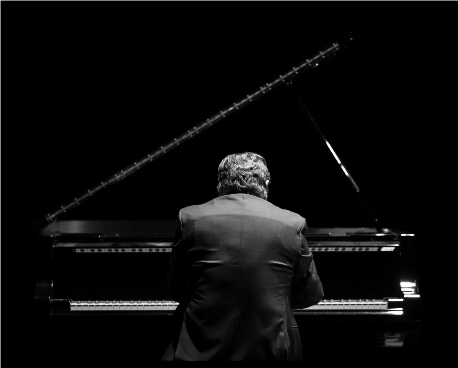 A pianist playing a composition on an elegant piano.