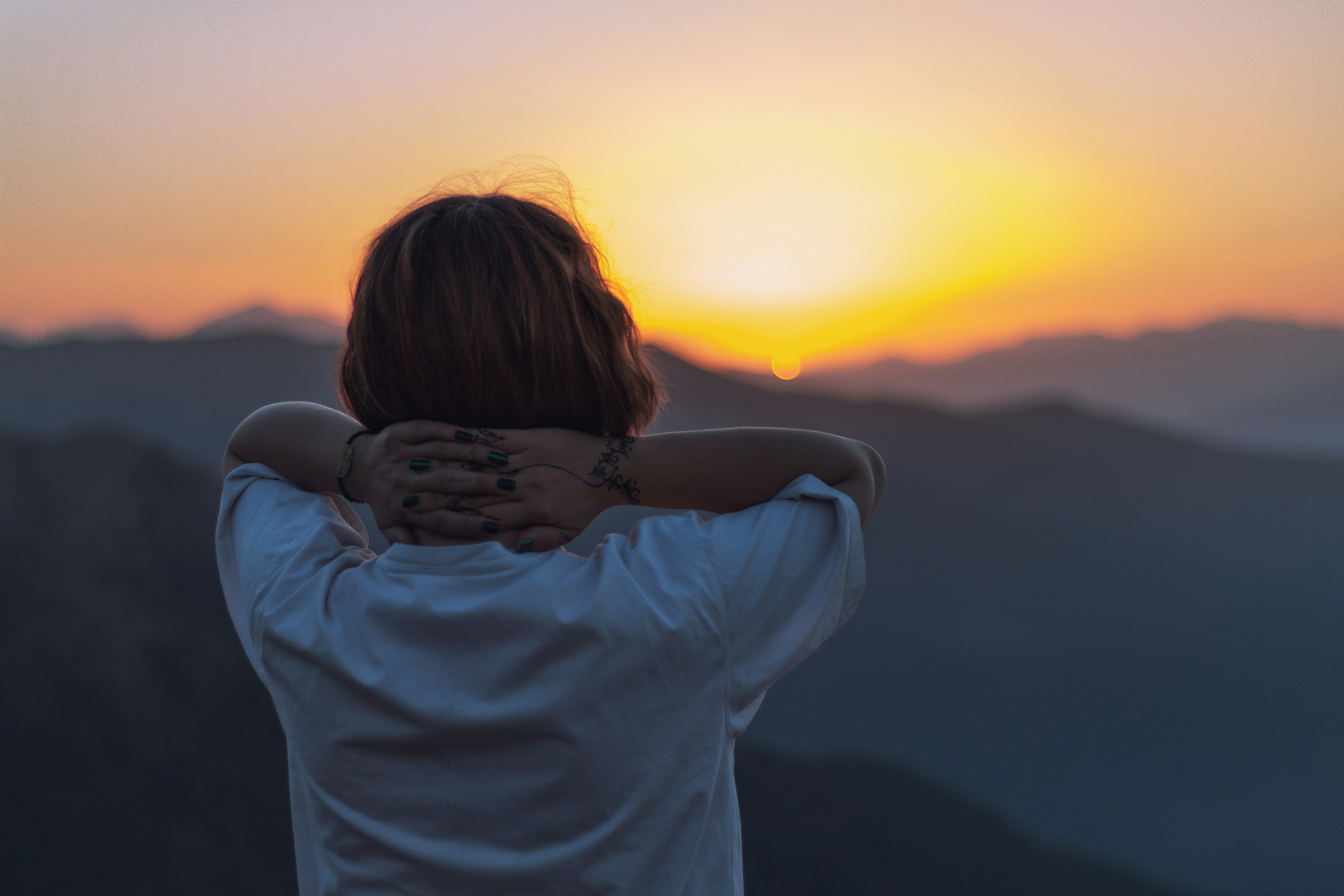 Woman gazing at the a mountain sunset