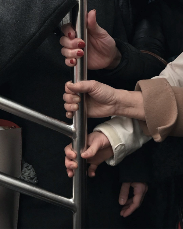 Hands holding onto a pole
