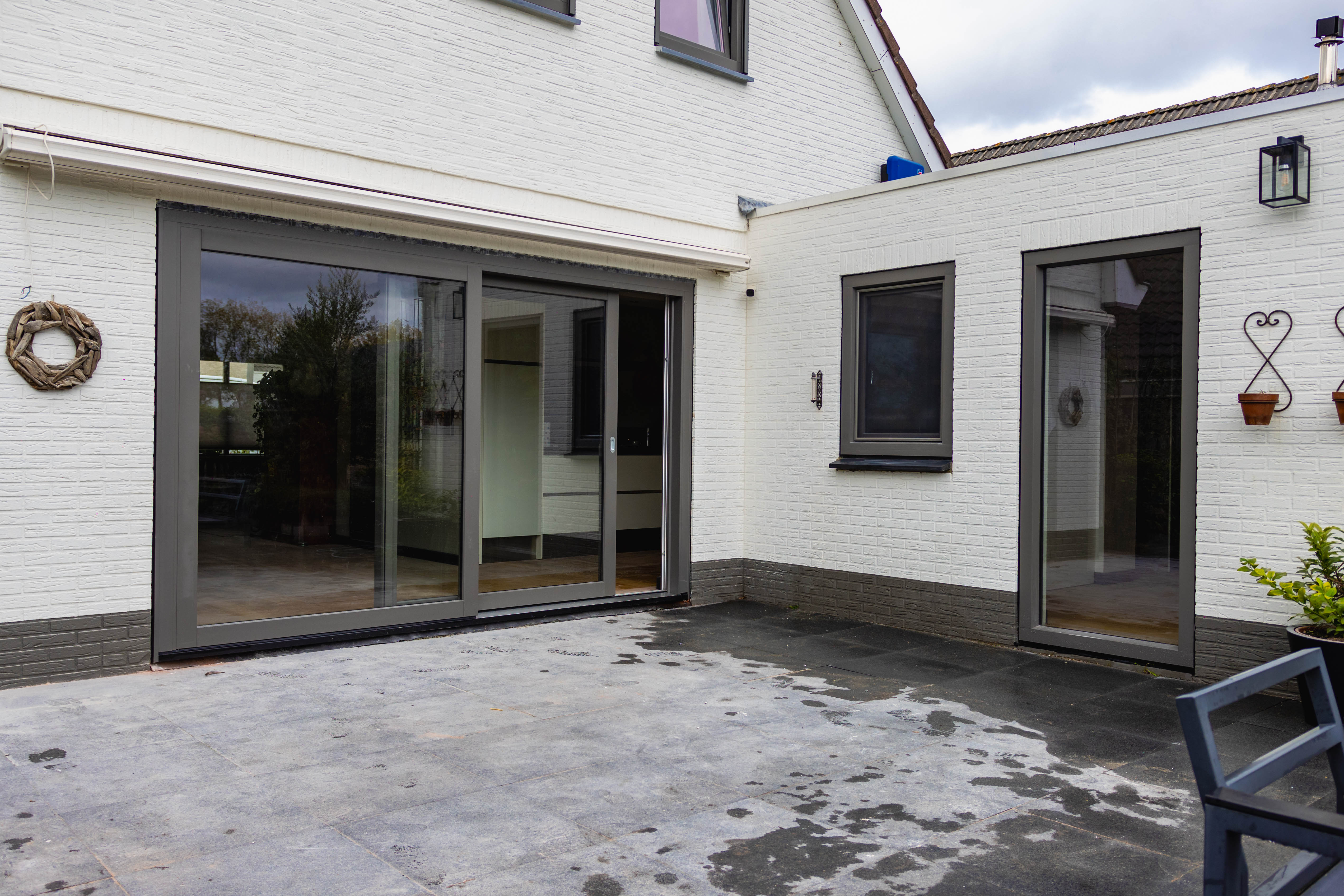 Witte woning met kunststof kozijnen en een grote schuifpui aan het terras