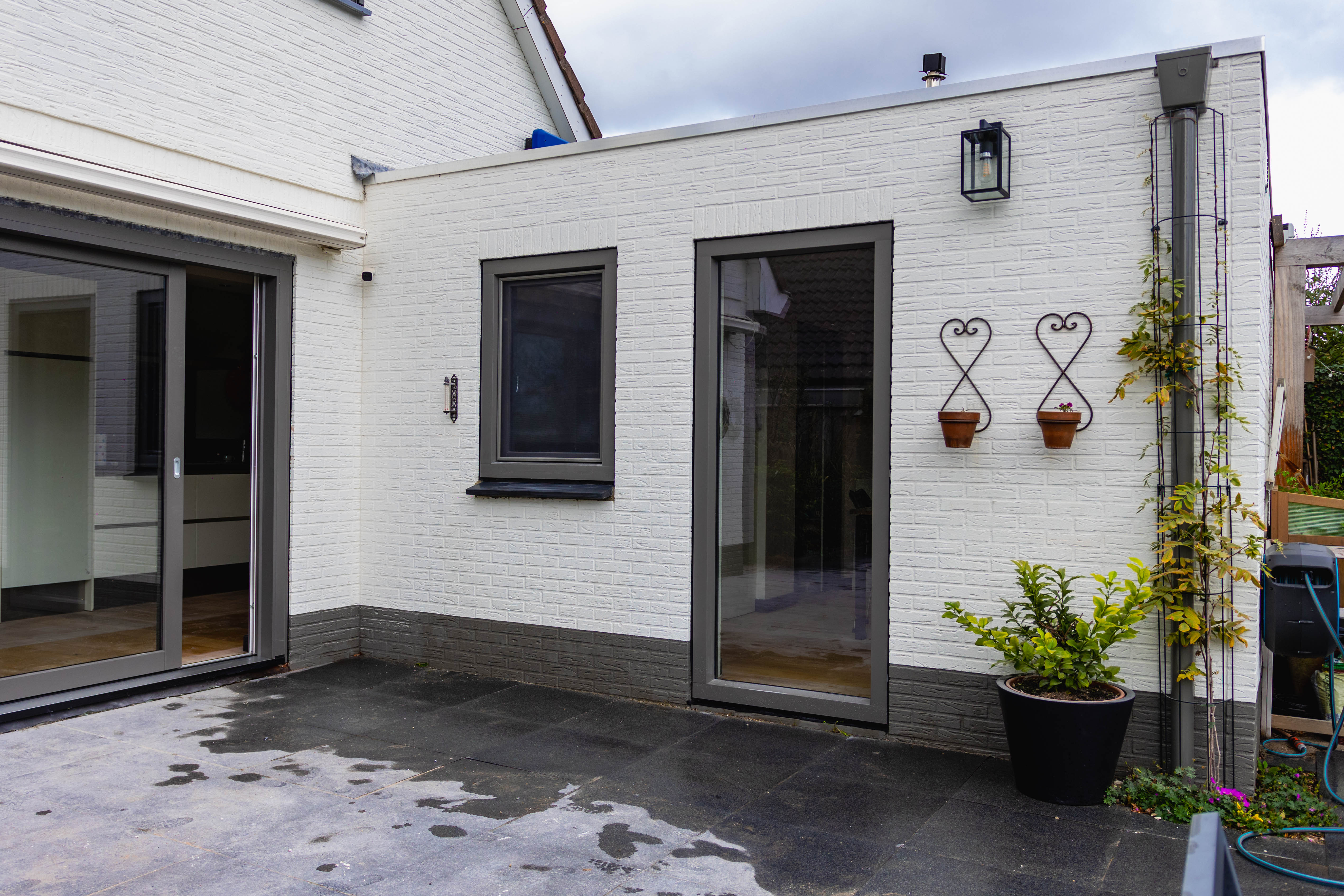 Witte woning met antraciet kunststof kozijnen en openslaande deuren