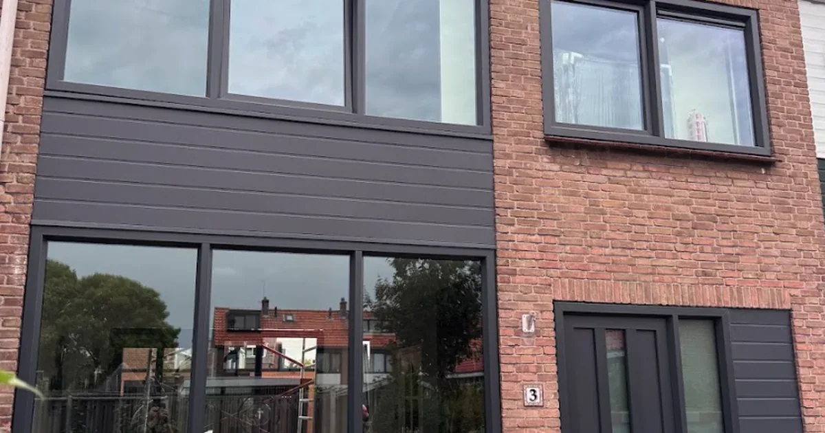 Rijtjeswoning met antraciet kunststof kozijnen en nieuwe donkere gevelbekleding