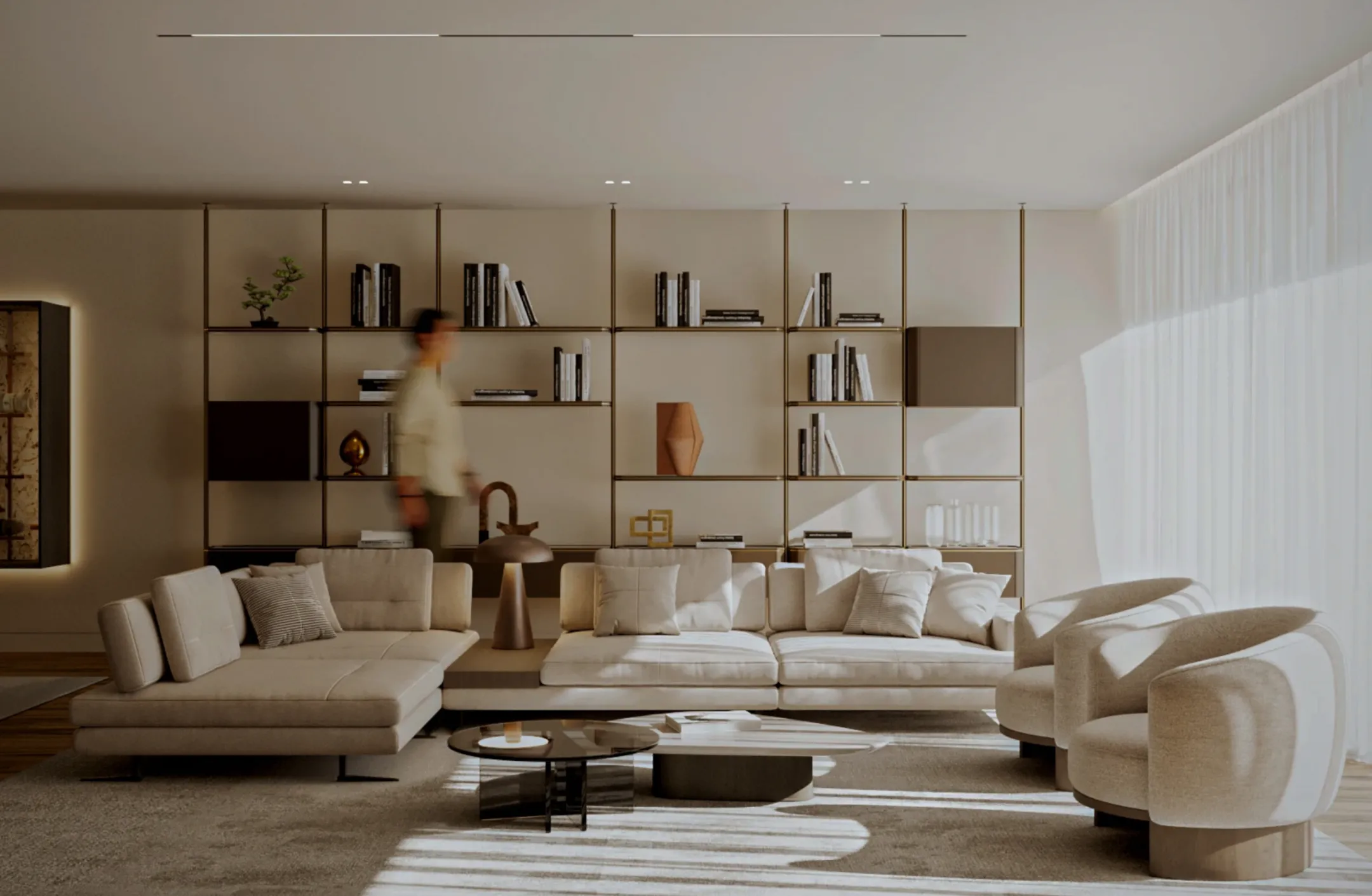 Sala de estar moderna com sofá bege, duas poltronas arredondadas, mesa de centro e estante com livros e decoração em fundo iluminado por luz natural.