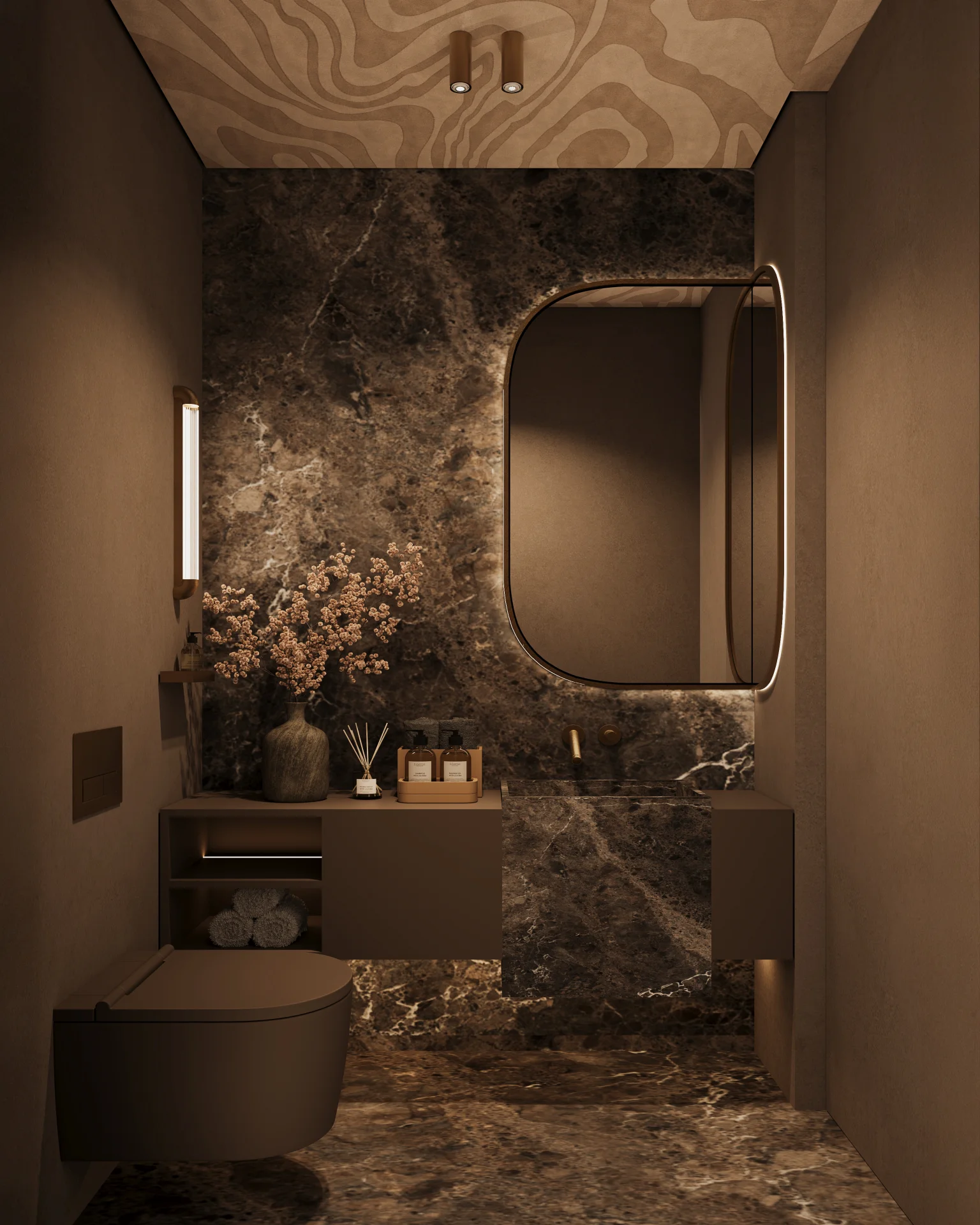 Banheiro moderno com decoração em tons marrons, parede e piso em mármore escuro, vaso sanitário suspenso, pia com espelho oval iluminado e acessórios decorativos.