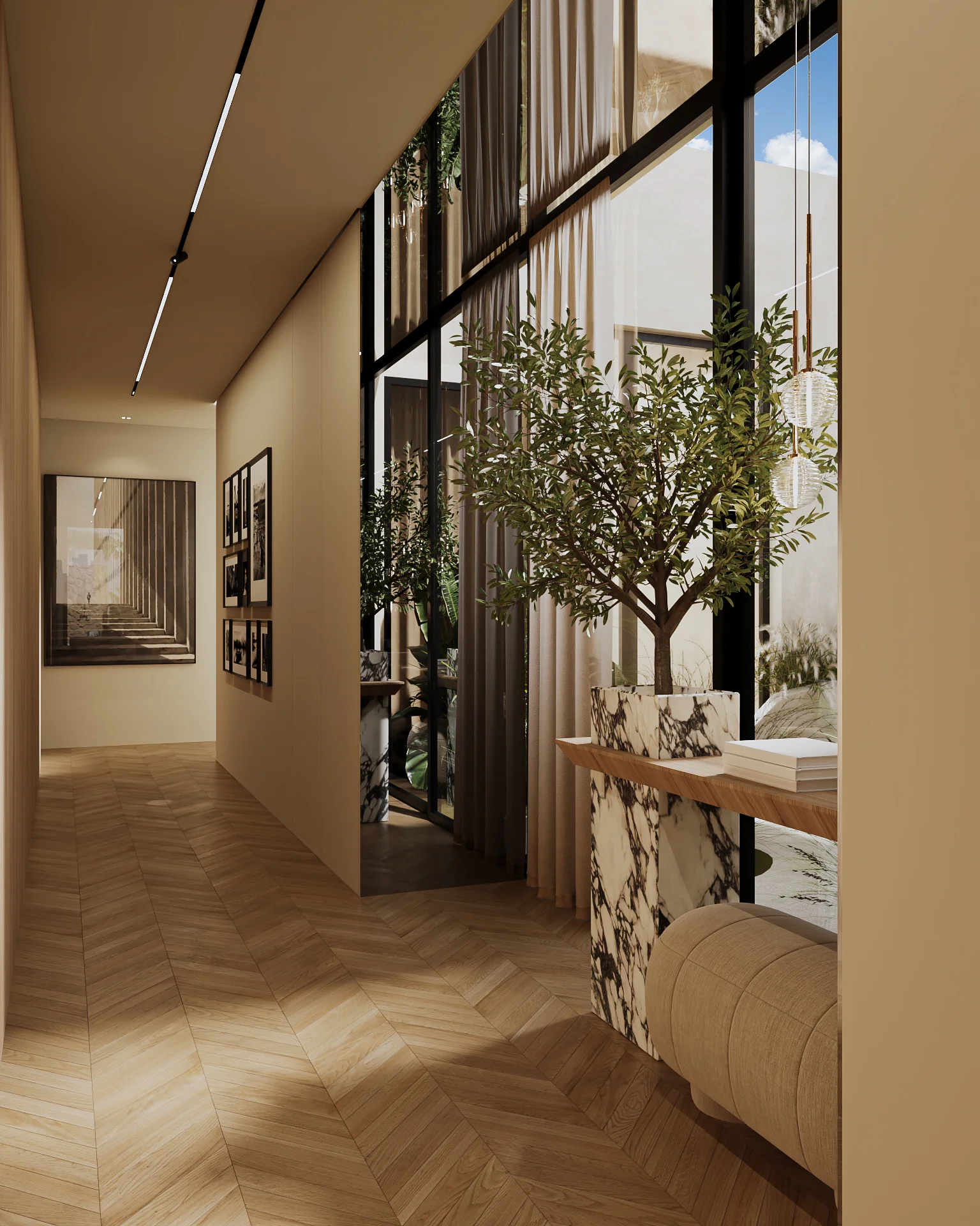 Corredor moderno com piso de madeira em padrão espinha de peixe, parede decorada com quadros em preto e branco, grande vaso de mármore com árvore, banco estofado bege e janelas amplas com cortinas.