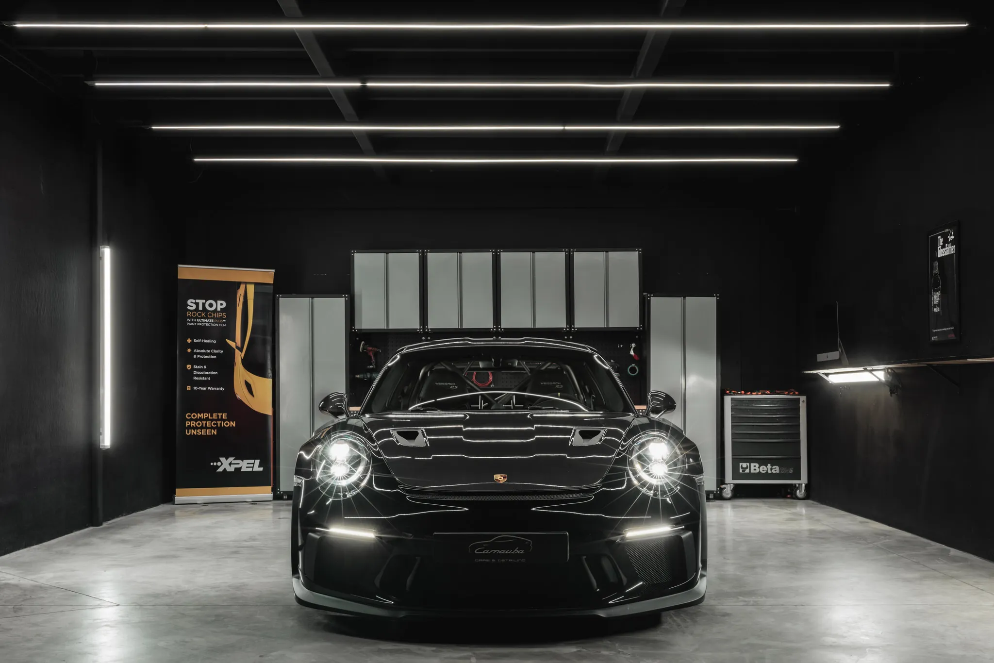Zwarte Porsche 911 GT3 in de verlichte detailingwerkplaats van Carnauba in Oostkamp