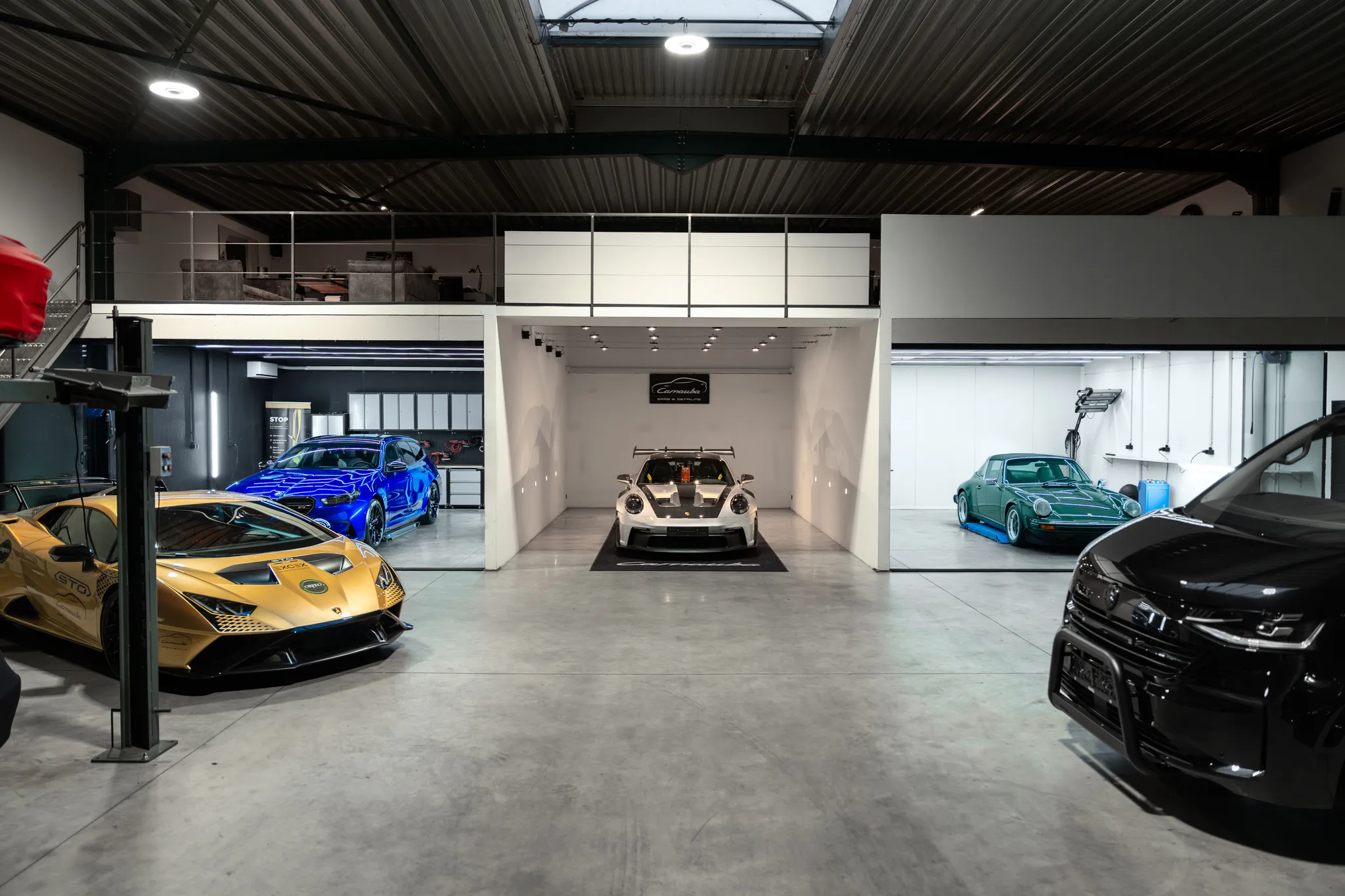 Werkplaats van Carnauba met een Lamborghini, een blauwe sportwagen en een Porsche in behandeling