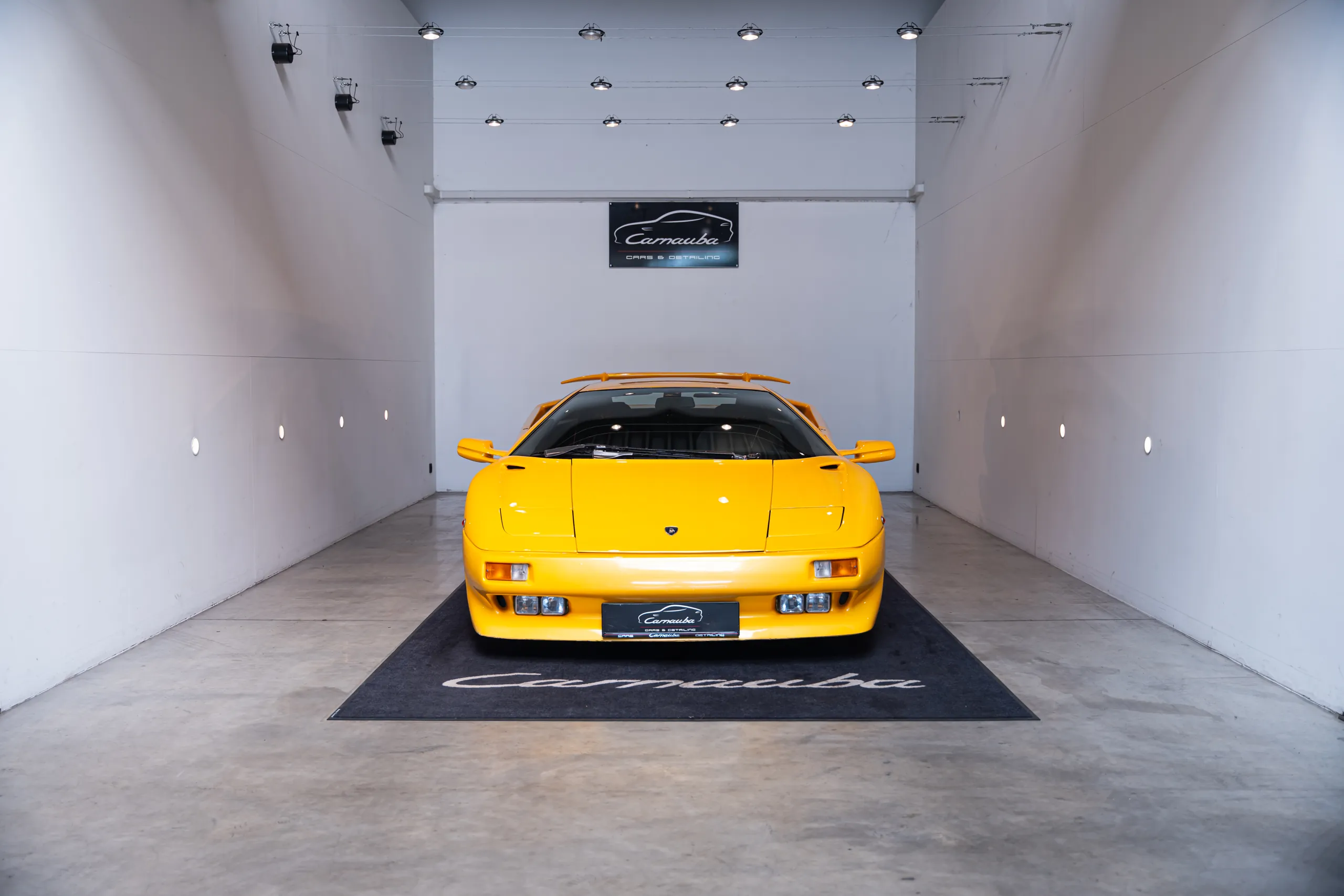 Gele Lamborghini Diablo op de Carnauba mat in de witte showroom
