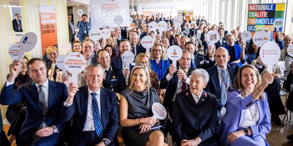 De koningin met veel anderen zittend om haar heen tijdens een bijeenkomst over de sportmarkt.