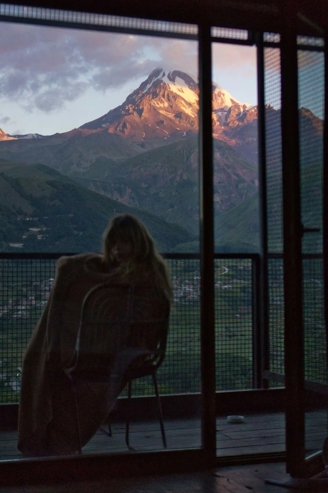 A pensive girl looking out at the mountain outside the window