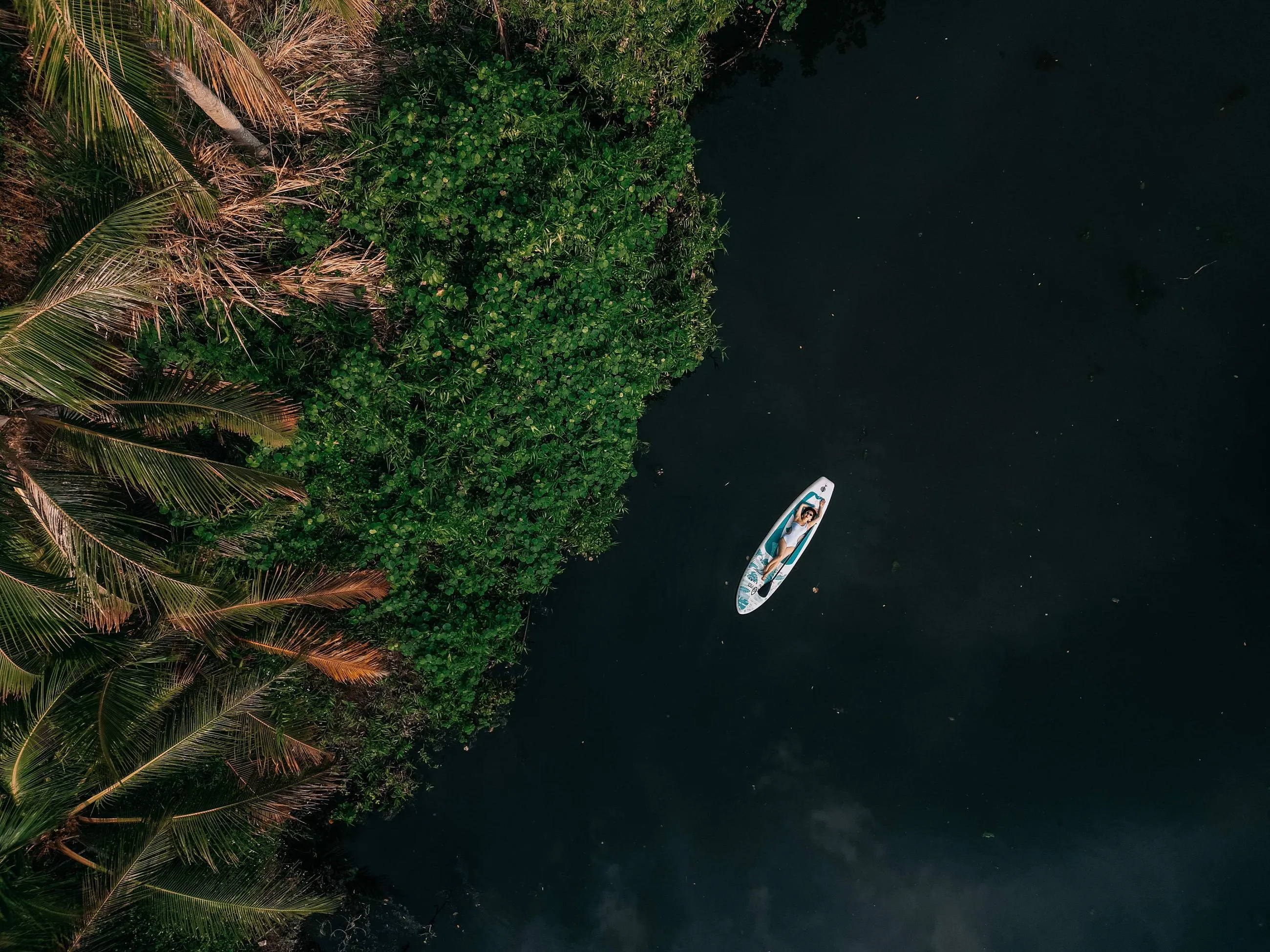 Grace is floating on a paddle board from an aerial view