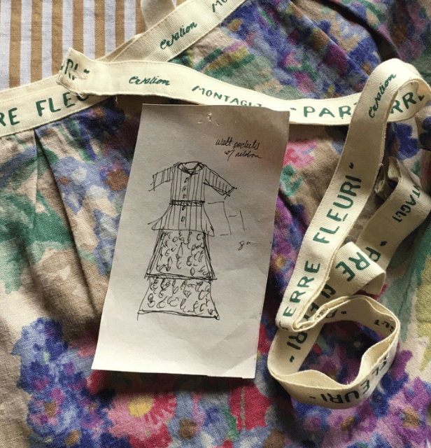 Hand-drawn fashion sketch of a tiered dress with belt and side pockets on floral patterned fabric with CREATION MONTAGUT-PARIS ribbon.