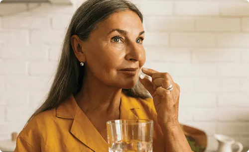 woman taking epitomee capsule with water