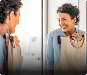 woman looking at clothes in mirror