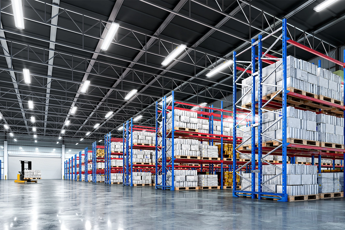 Large warehouse with bright overhead lighting and tall shelves stocked with pallets