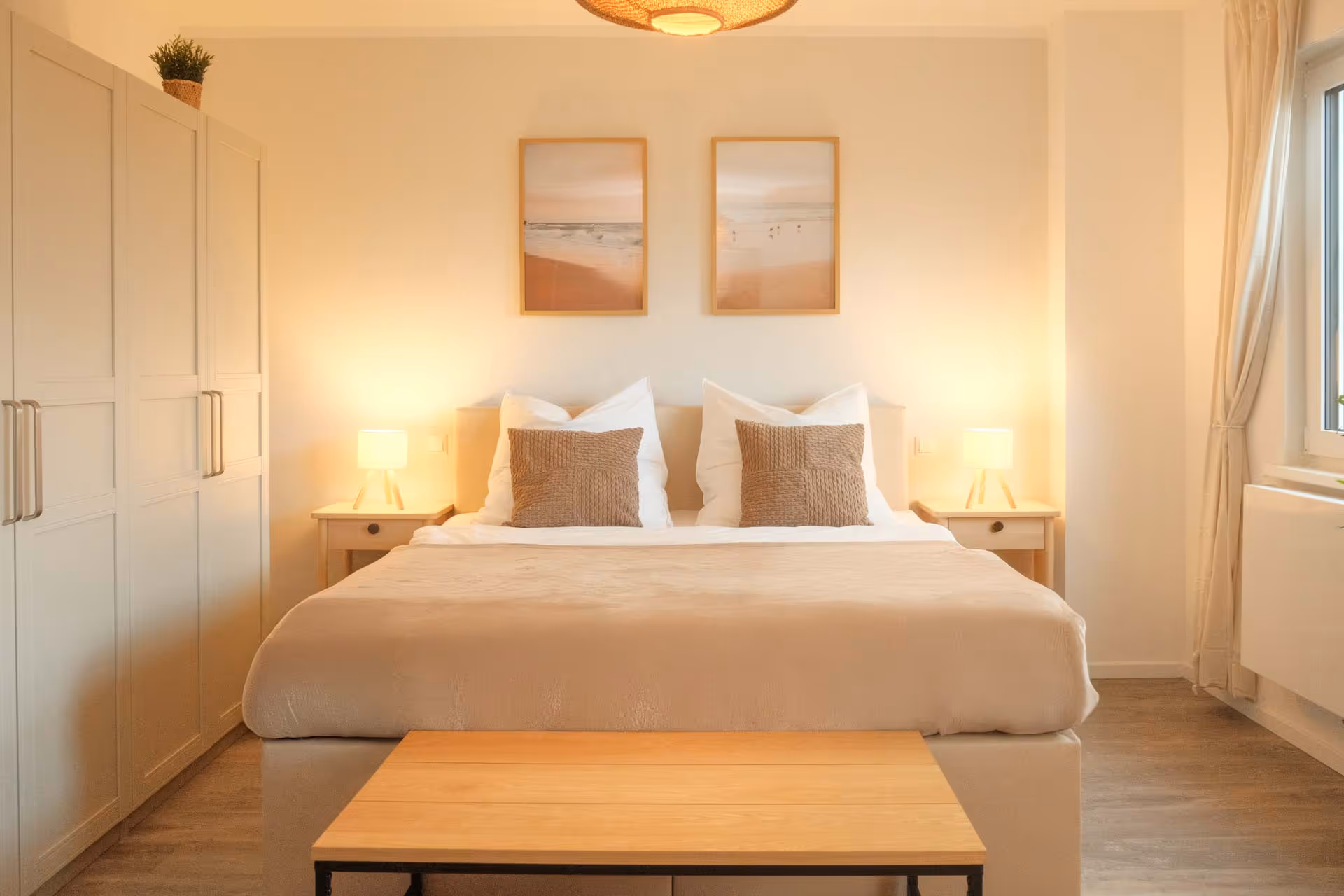 Doppelbett mit Nachttischen und Wandbildern