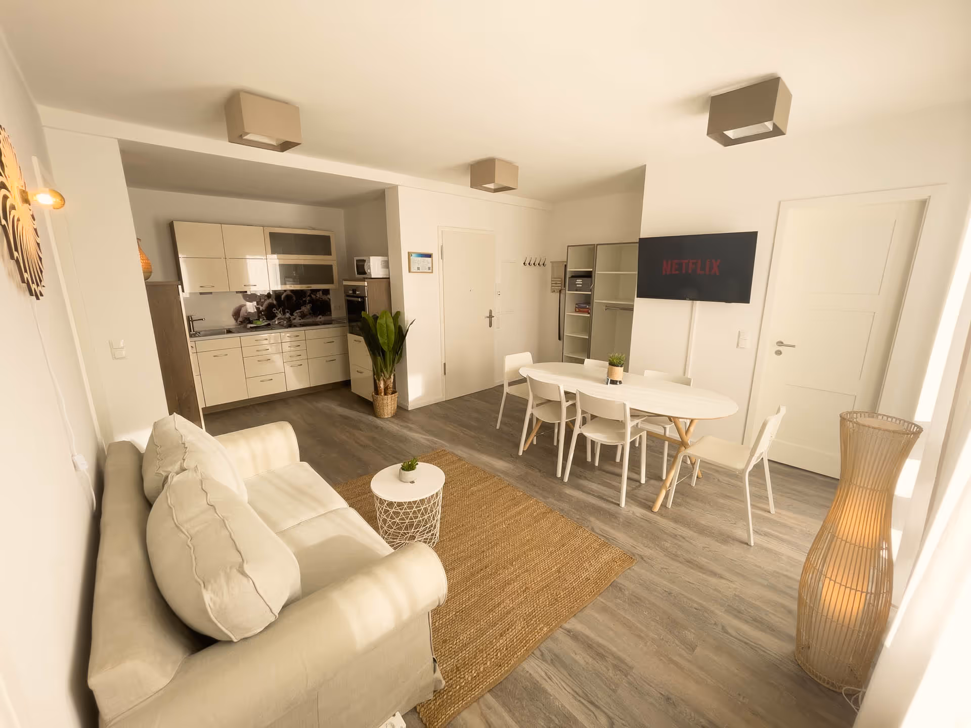 Heller Wohnbereich mit Sofa, Essplatz, Tv und Kueche