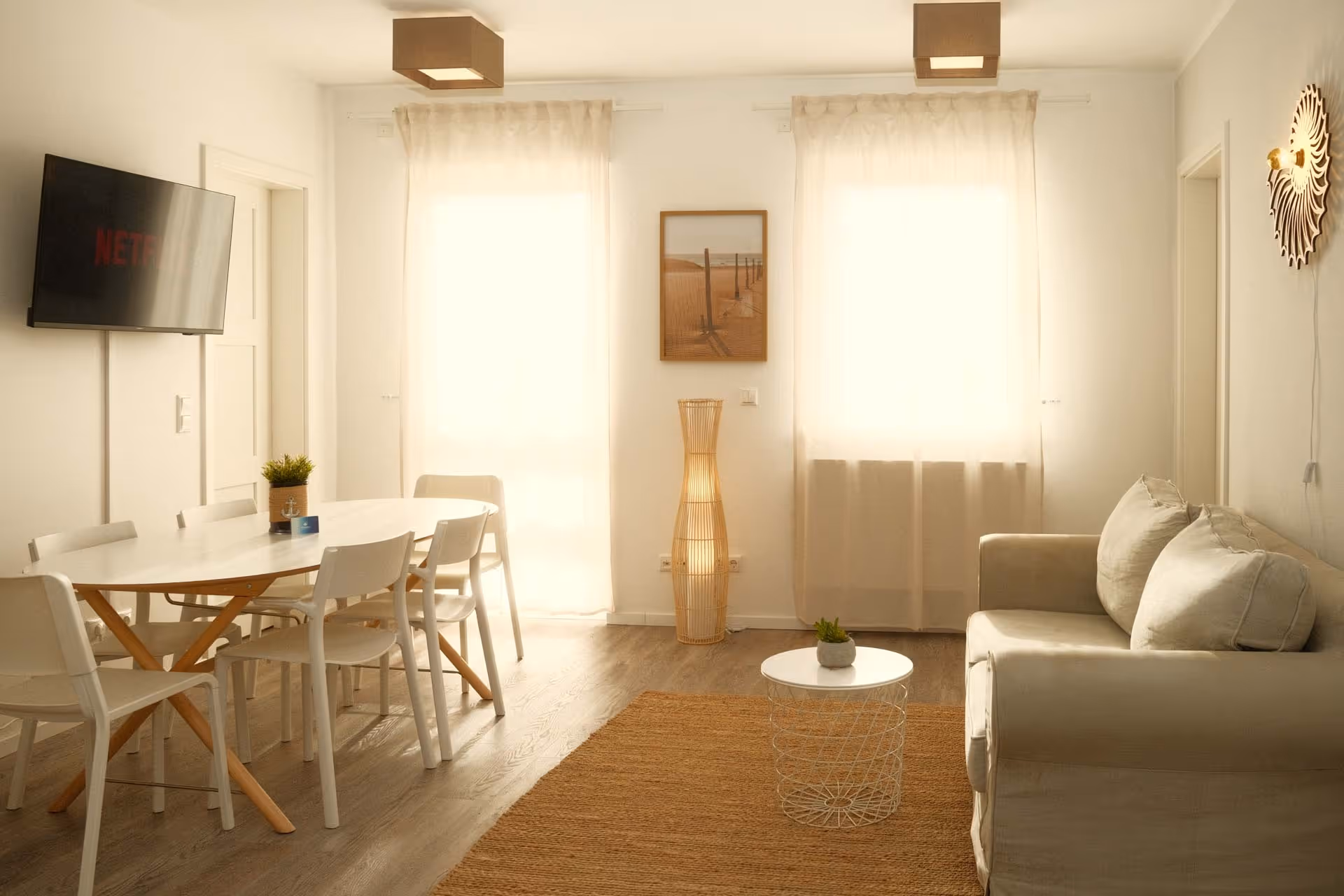 Sofa und Esstisch zwischen zwei Fenstern