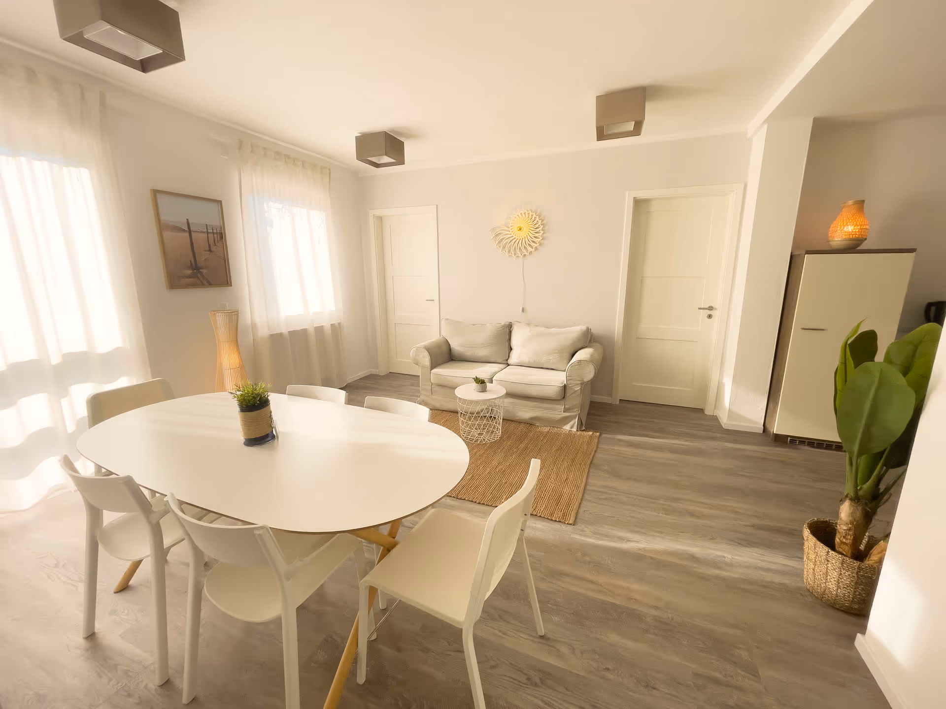 Wohnzimmer mit Sofa, Esstisch und Wandbild