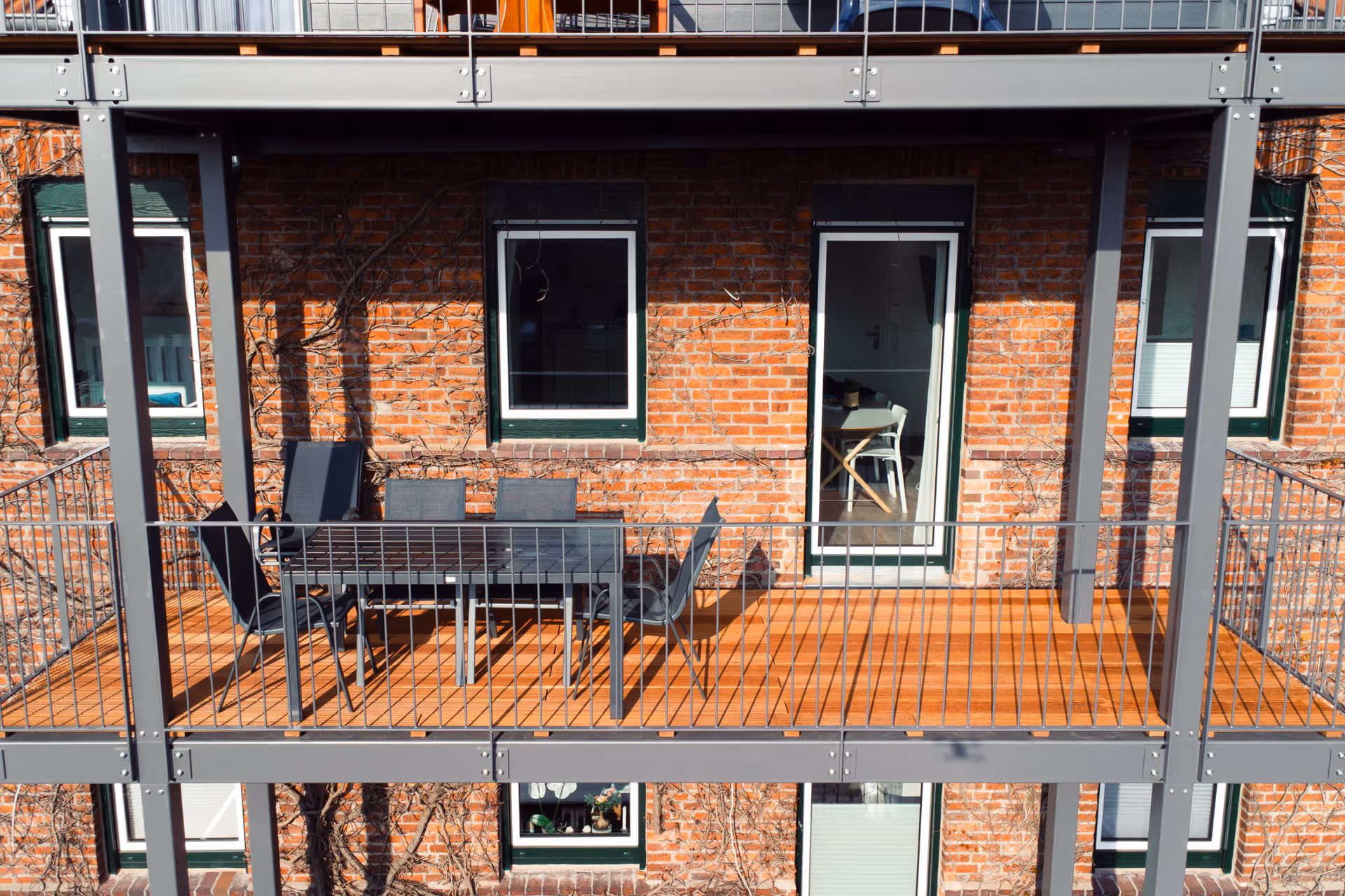 Balkon mit Tisch und sechs Stuehlen aus der Naehe