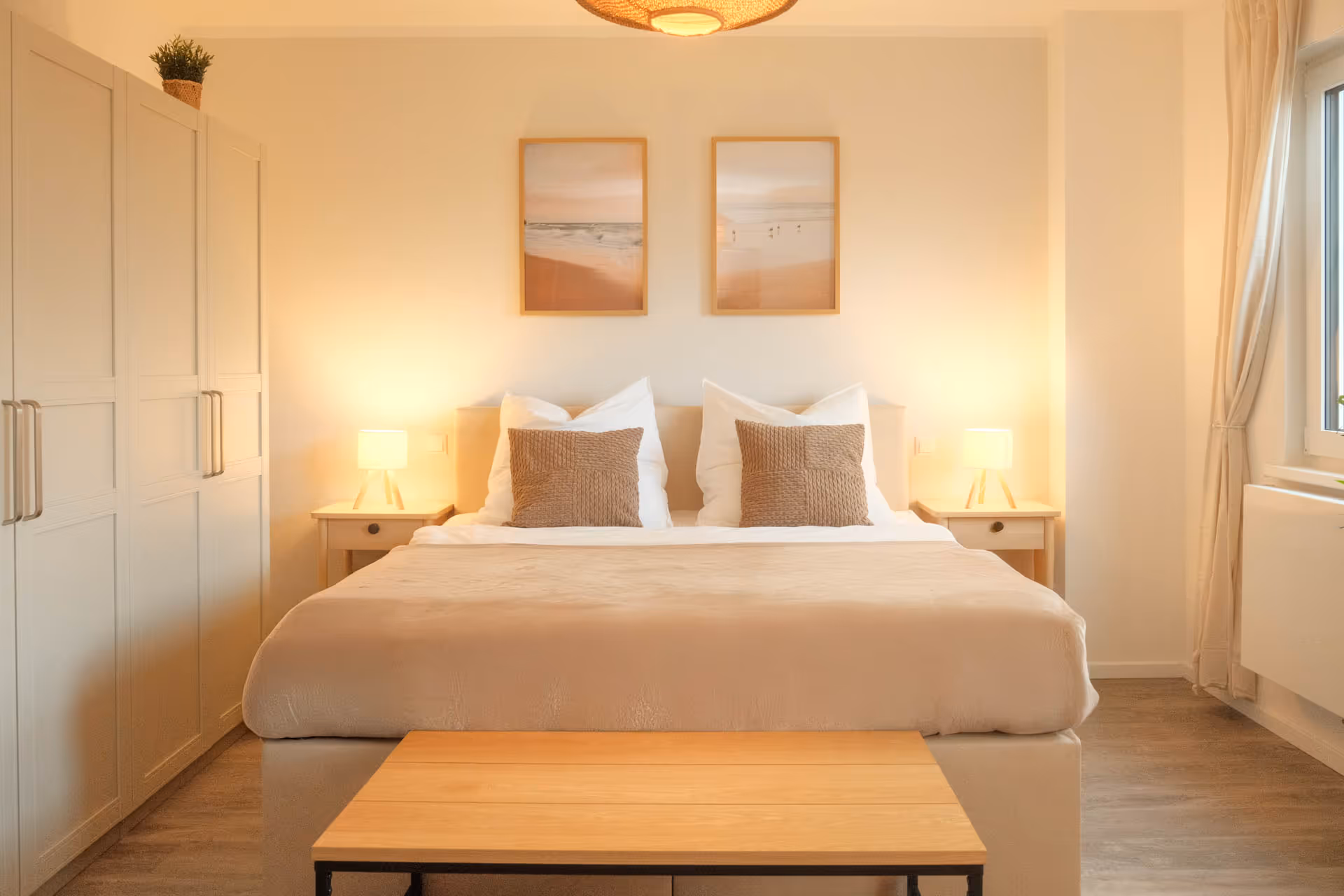 Doppelbett mit Nachttischen und Bildern mit warmen Licht