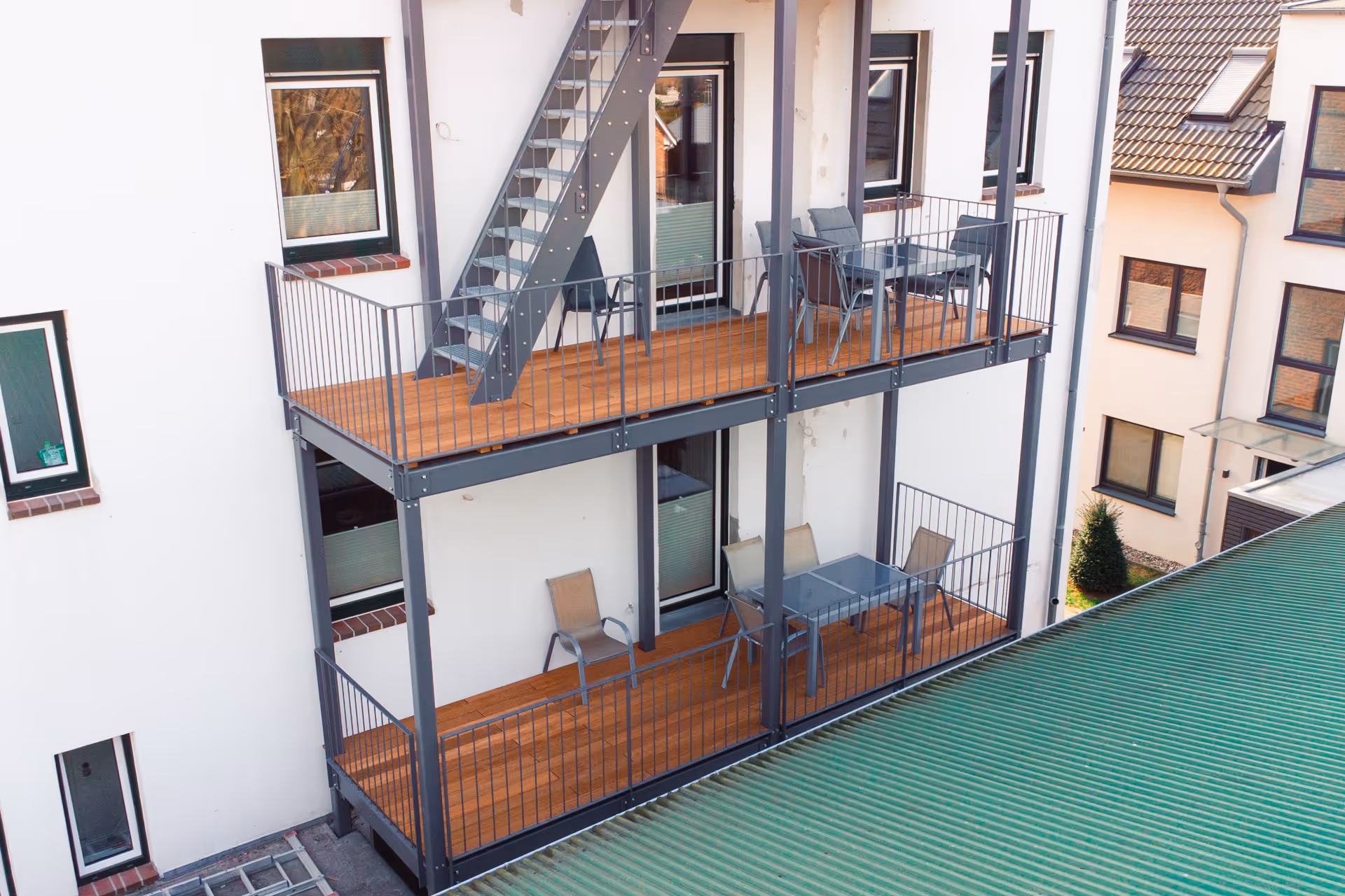 Zwei Balkone mit Tisch und Stuehlen