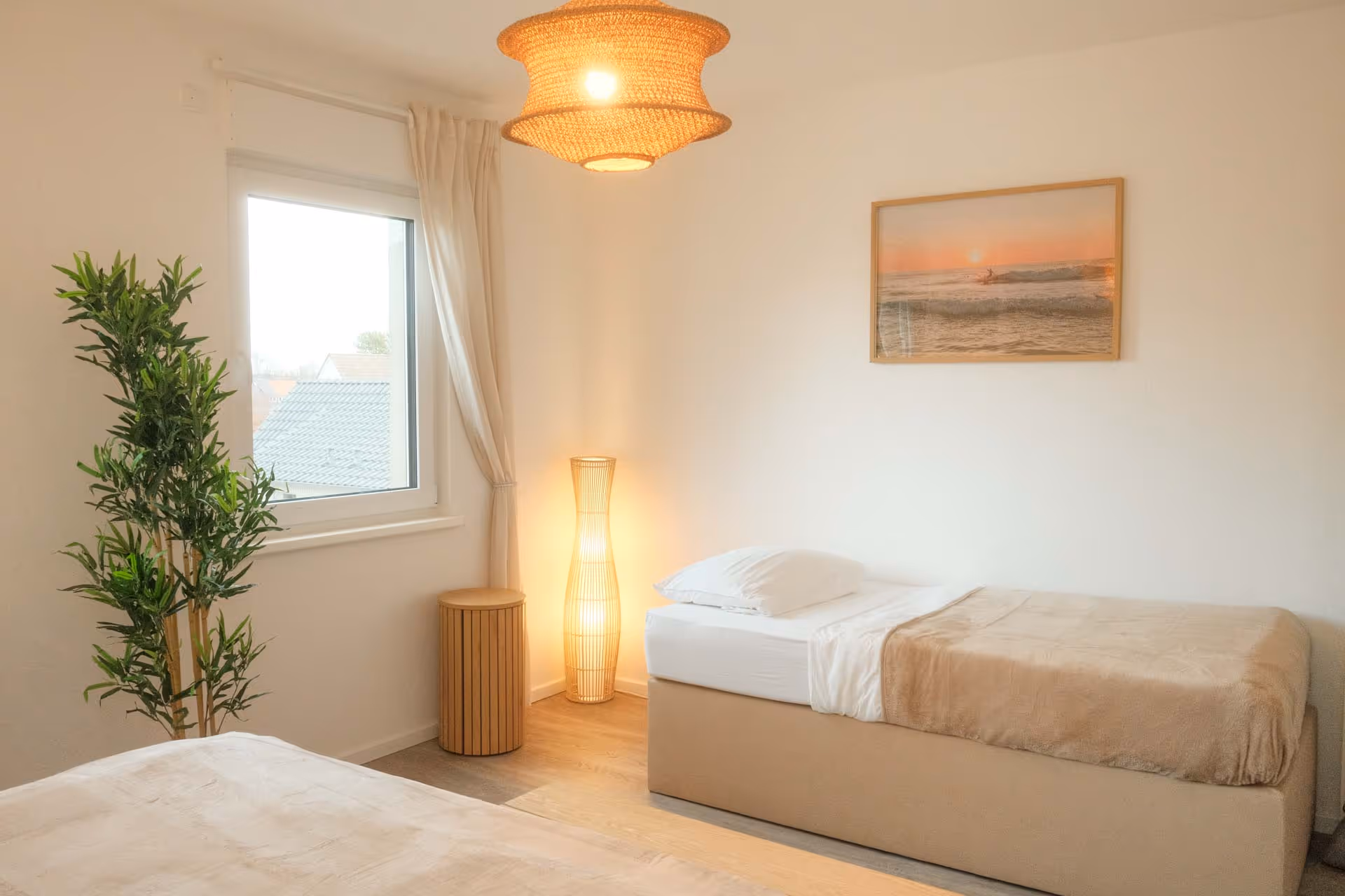 Einzelbett mit Fenster und Pflanze